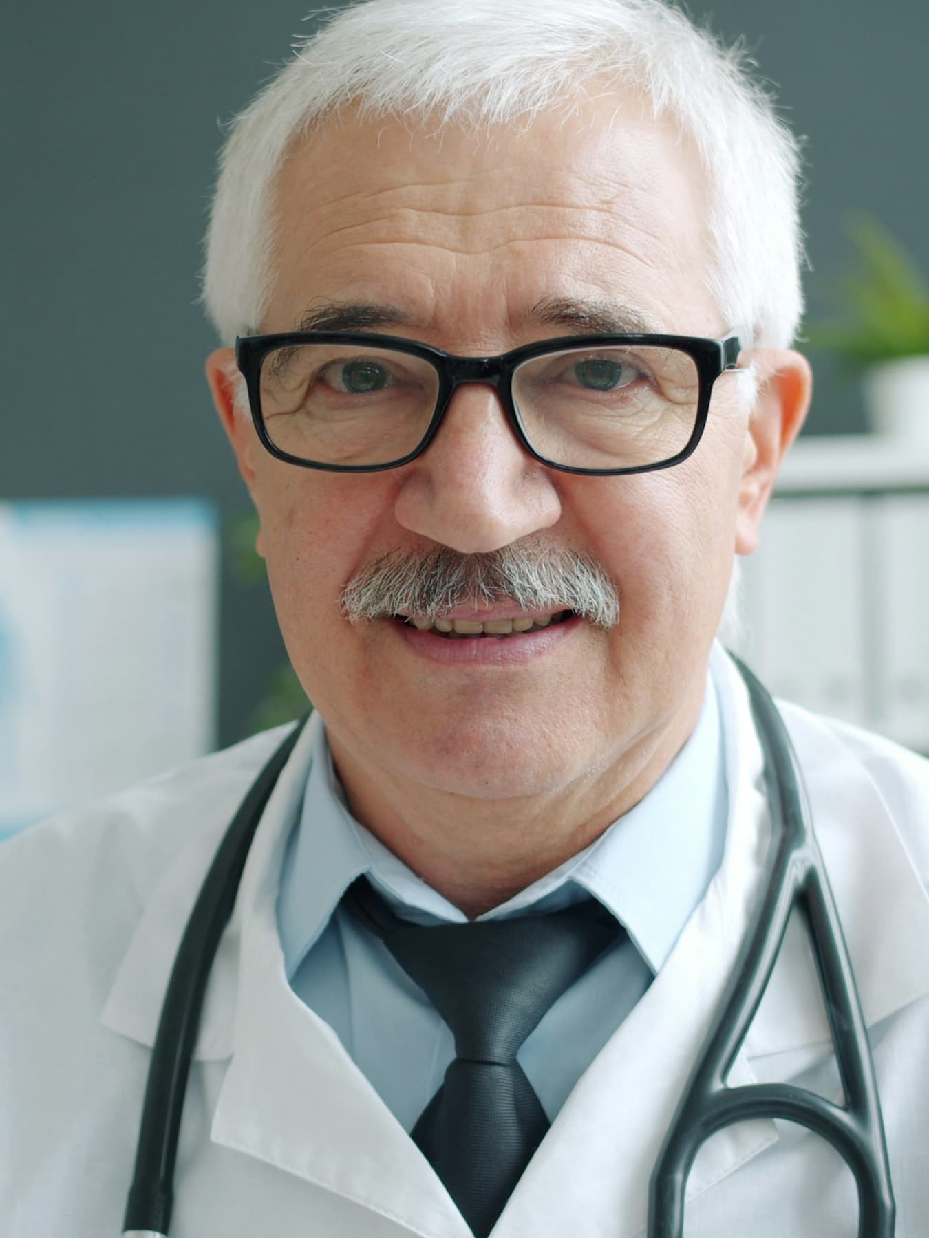 A physician reviewing paperwork at a desk in a quiet office